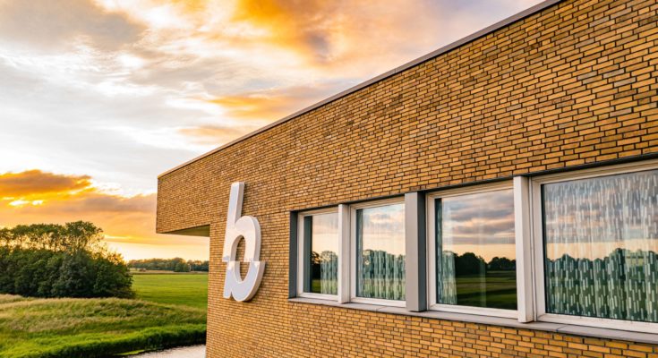 het hoofdkantoor van hamilton bright ingezoomd op het logo met een zonsondergang op de achtergrond