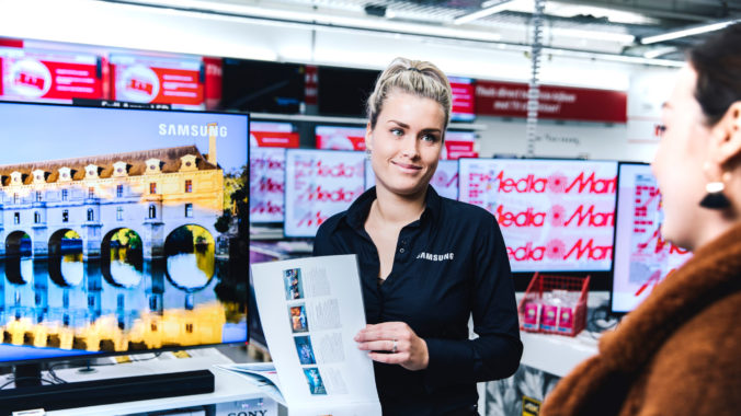 Een verkoopster in de MediaMarkt vertelt een klant meer over een Samsung televisie